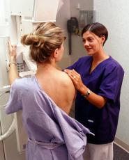 This is a picture of a women getting a mammogram and a technician standing next to her